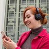 Meisje draagt ​​Studio Bluetooth draadloze koptelefoon op het oor in het zwart