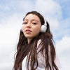 Meisje draagt ​​Studio Bluetooth draadloze koptelefoon op het oor in het wit