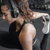 Woman Stretching in Gym Wearing Flex Sport Wireless Bluetooth Headphones