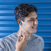 Kerl trägt JBuds Pro Bluetooth Signature Earbuds in blau