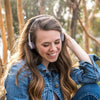 Dívka, která nosí bezdrátová retro sluchátka Rewind v bílé barvě
