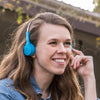 Mädchen, das drahtlose Retro-Kopfhörer des Rücklaufs in Blau trägt
